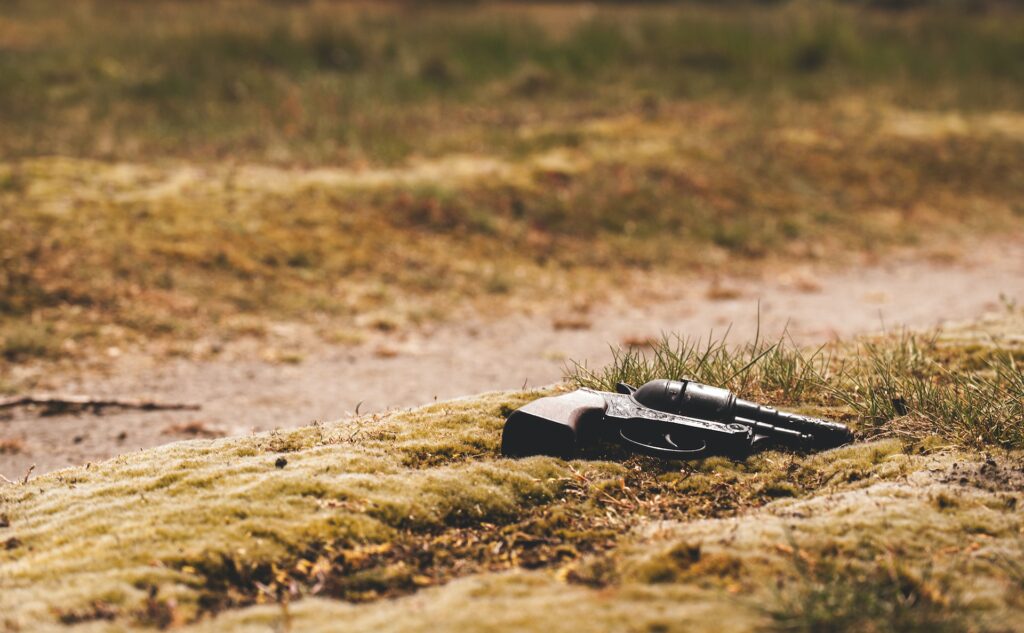 A handgun laying in the grass, representing the case of R. v. Corner and the exclusion of evidence unlawfully obtained in violation of an accused's Charter rights